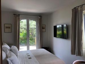a bedroom with a bed and a window at le Mas des Pignes -adults only in Aix-en-Provence