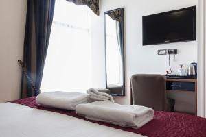 
a hotel room with a bed and a television at The Clarendon Royal Hotel in Gravesend
