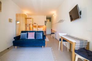 ein Wohnzimmer mit einem blauen Sofa und einem Tisch in der Unterkunft Vitória over the roofs II in Porto