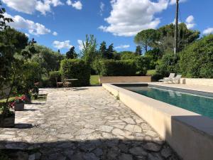 einen Hinterhof mit einem Pool und einer Terrasse in der Unterkunft le Mas des Pignes -adults only in Aix-en-Provence