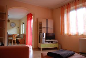 a living room with a couch and a tv and a window at Haus Brenntara 1 in Rangersdorf