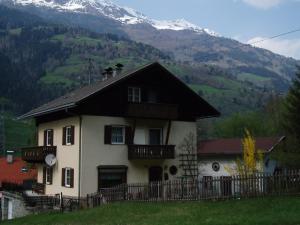 a house with a fence in front of a mountain at Haus Brenntara 1 in Rangersdorf