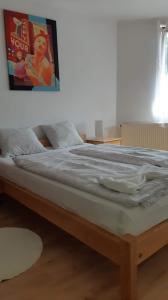 a bed in a room with a poster on the wall at Rege apartman in Alsóörs