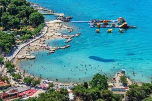 a beach with a bunch of people in the water at Apartmani Križanović in Vodice