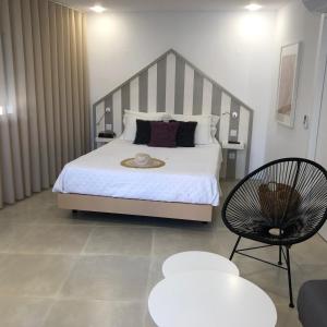 a bedroom with a large bed and a chair at Casa do Joaquim da Praia in Nazaré +33 photos
