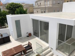 a balcony with a table and a bench on a building at Casa do Joaquim da Praia in Nazaré