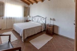 a bedroom with a bed and a table and a window at Villa Con Piscina Vista Mare in Cala Bitta