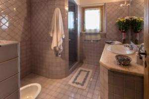 a large bathroom with two sinks and a shower at Villa Con Piscina Vista Mare in Cala Bitta +15 photos