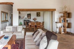 - un salon avec un canapé et une salle à manger dans l'établissement Villa Con Piscina Vista Mare, à Cala Bitta