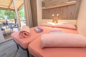 dwa łóżka w pokoju z różową pościelą w obiekcie Campsite Eurokamp Raca w mieście Sveti Juraj