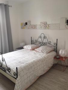 Schlafzimmer mit einem Bett mit einer schwarzen und weißen Bettdecke in der Unterkunft Gite MARGUERITTE in Fresnes-en-Woëvre