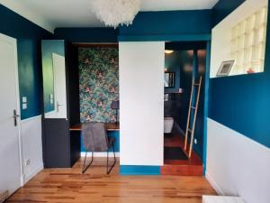 sala de estar con paredes azules y silla en VILLA SAINT VINCENT, en Agen