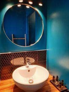 La salle de bains est pourvue d'un lavabo blanc et d'un miroir. dans l'établissement VILLA SAINT VINCENT, à Agen