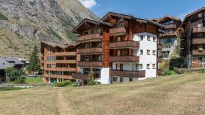 duży budynek z drewnianymi balkonami na wzgórzu w obiekcie Chez Nous Zermatt w mieście Zermatt