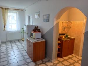 a kitchen with an archway and a microwave on a counter at Nad Bieszczadzkim Morzem in Polańczyk