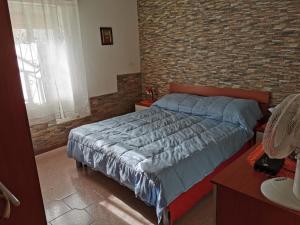 - une chambre avec un lit et un mur en briques dans l'établissement L'angolo di Paradiso, à Alcamo