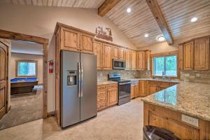 a kitchen with wooden cabinets and a stainless steel refrigerator at Outdoor Adventure Hub about 20 Miles to Yellowstone! in Island Park
