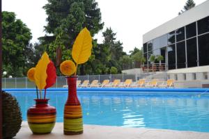 
three colorful umbrellas are in a pool of water at Howard Johnson Plaza Resort & Casino Mayorazgo in Paraná
