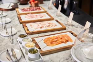 a table topped with three cutting boards filled with food at Sir Anthony in Playa de las Americas