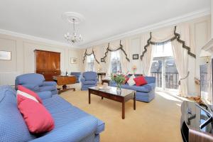 a living room with blue couches and a table at No1 The Mansions By Mansley in London