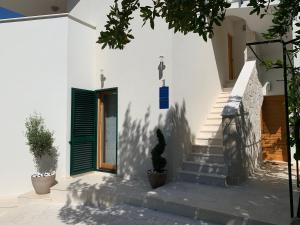 een wit gebouw met een groene deur en een trap bij Villa Providenca in Vodice