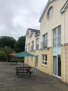 a picnic table with an umbrella in front of a building at Glancys Accomadation in Carrick on Shannon