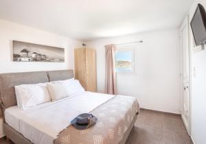 a bedroom with a bed with a hat on it at Central Suites Mykonos in Mýkonos City