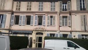 カンヌにあるResidence Saint Marcのピンクの建物の前に停まった白いバン
