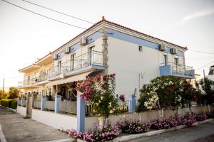 a white building with flowers in front of it at Diamanti Studios in Skala Kallonis