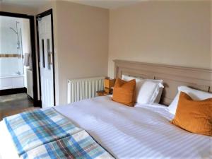 a bedroom with a bed with orange and blue pillows at Corsewall Arms Guest House in Stranraer