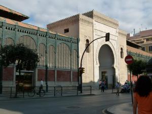 um grande edifício com um arco numa rua da cidade em Low cost room Mercado Malaga em Málaga
