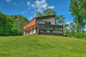 a house on top of a grassy hill at Luxe and Modern Home 30Mi to Saratoga Springs! in Argyle