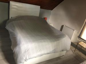 - un lit blanc dans une chambre avec fenêtre dans l'établissement Clos de la fontaine A, à Villiers-Saint-Frédéric