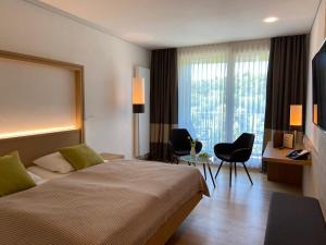 une chambre d'hôtel avec un lit, une table et des chaises dans l'établissement Hotel Zur Schönen Aussicht, à Marktheidenfeld