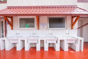 a row of sinks in a bathroom with windows at Campsite Eurokamp Raca in Sveti Juraj