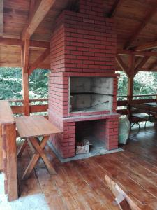 - une cheminée en briques sur une terrasse avec une table en bois dans l'établissement D.W. Lidia, à Korbielów