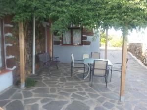 a patio with a table and chairs under a tree at Casa Anita in Tajace de Abajo