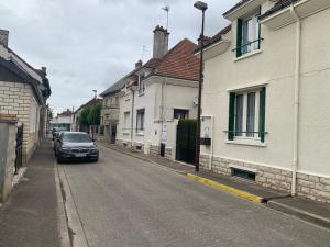 un coche está conduciendo por una calle con casas en Gîte Arcis sur Aube en Arcis-sur-Aube