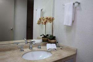 a bathroom with a sink with towels and a mirror at Hotel Poza Rica Centro in Poza Rica de Hidalgo +86 photos