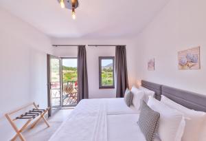 una camera bianca con letto e balcone di Thomas Suites Datça a Datça