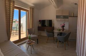 een woonkamer met een bank en een tafel met stoelen bij Villa Providenca in Vodice