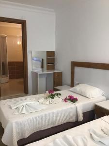 1 dormitorio con 2 camas con flores en Altunakar 1 Hotel, en Didim