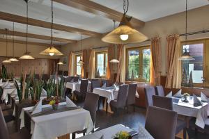 a restaurant with white tables and chairs and windows at Hotel Gasthof Fenzl in Steinberg