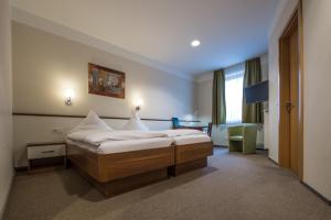 a hotel room with a bed and a chair at Hotel Gasthof Fenzl in Steinberg