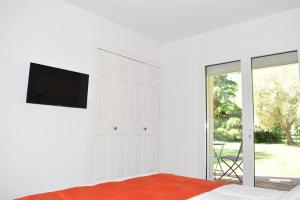 a bedroom with a bed with a flat screen tv on a wall at La Villa Saint André - Argeles sur mer in Argelès-sur-Mer