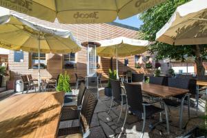 a patio with tables and chairs and umbrellas at Hotel Gasthof Fenzl in Steinberg