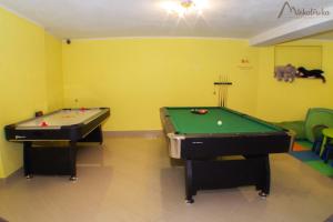dwa stoły bilardowe w pokoju z żółtymi ścianami w obiekcie Willa Michałówka w Zakopanem