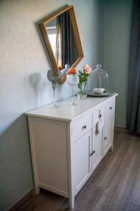 a dresser with two wine glasses and a mirror on it at Ferienwohnung Gräfe in Stöckey