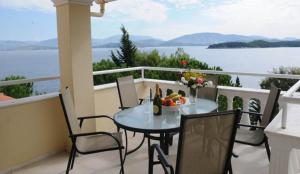 a dining room table with a balcony overlooking the ocean at Kassiopi Bay in Kassiopi