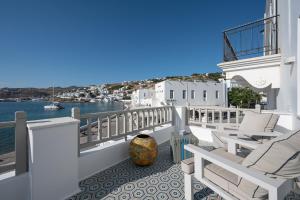 a balcony with chairs and a view of the water at Pnoe in Mýkonos City